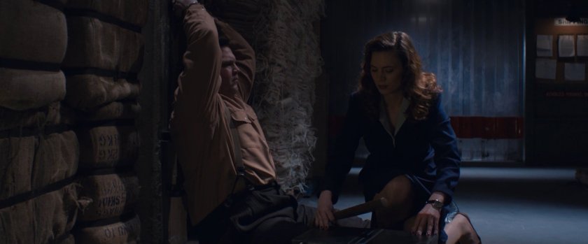 Peggy Carter tying man up inside warehouse.