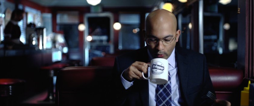 Agent Sitwell drinking coffee in a diner.