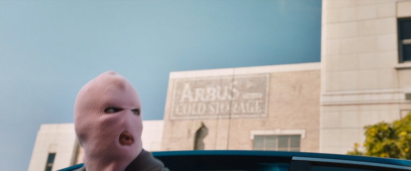 Claire with pink ski mask exiting car.