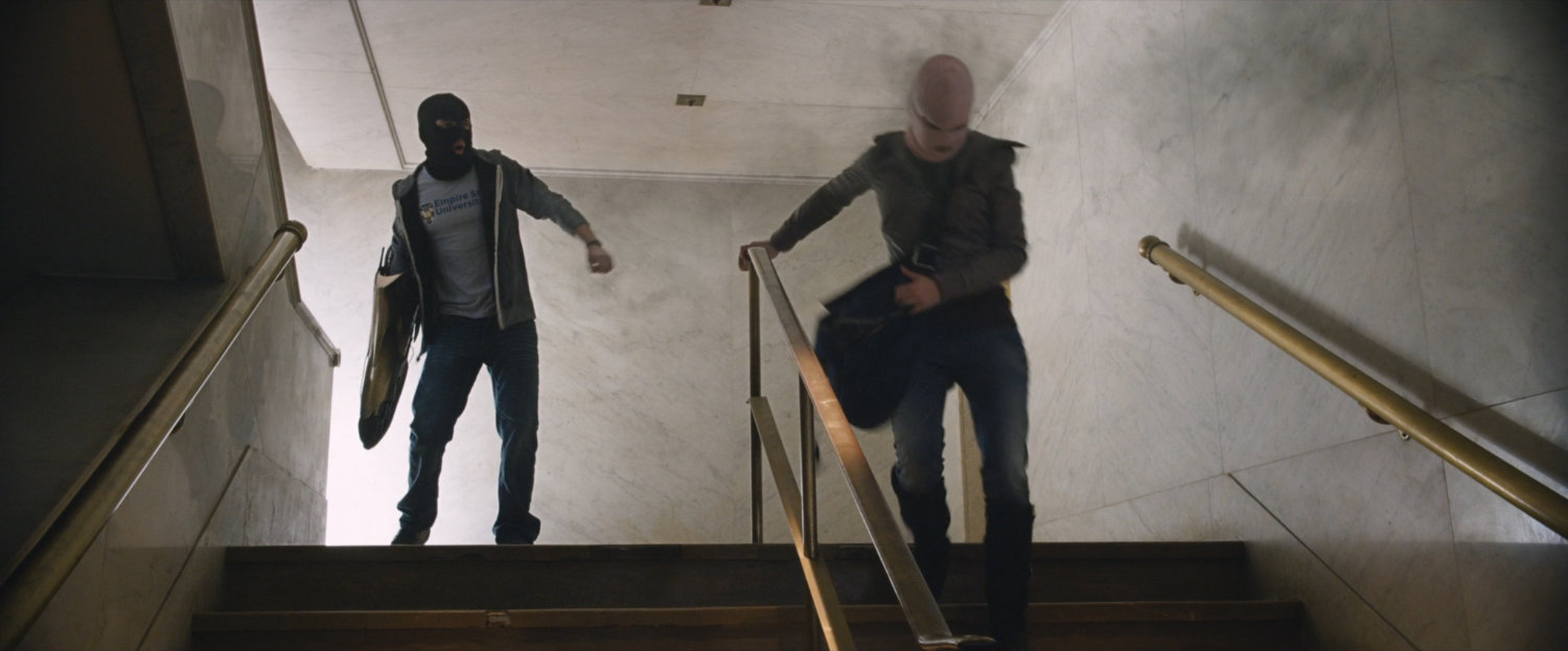 Benny and Claire on stairs inside bank.