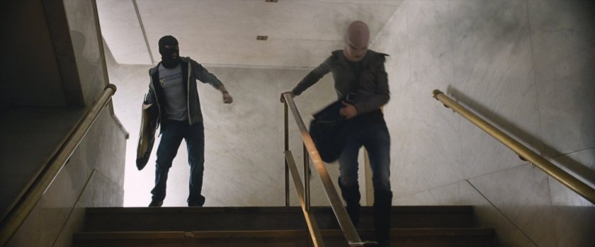 Benny and Claire on stairs inside bank.