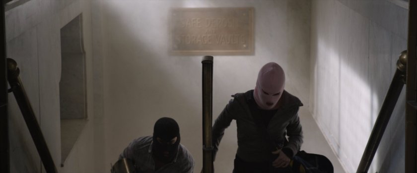 Benny and Claire on stairs inside bank.