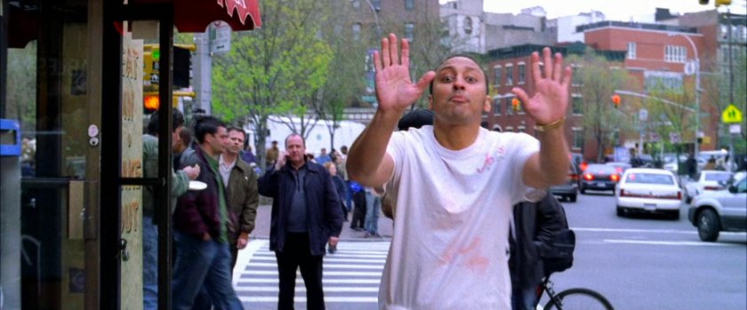 Mr Aziz holding his hand up to stop on sidewalk.