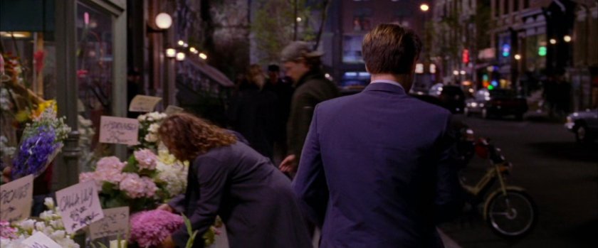 Peter Parker walking away from sidewalk flower stand.