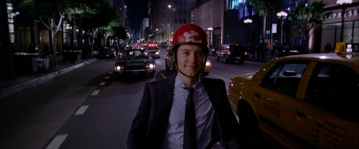 Peter Parker riding his moped at night.