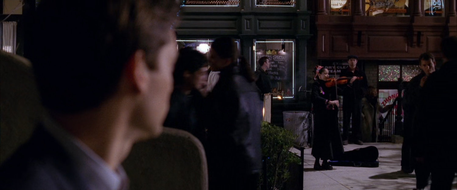 Peter Parker sees woman playing violin on street corner.