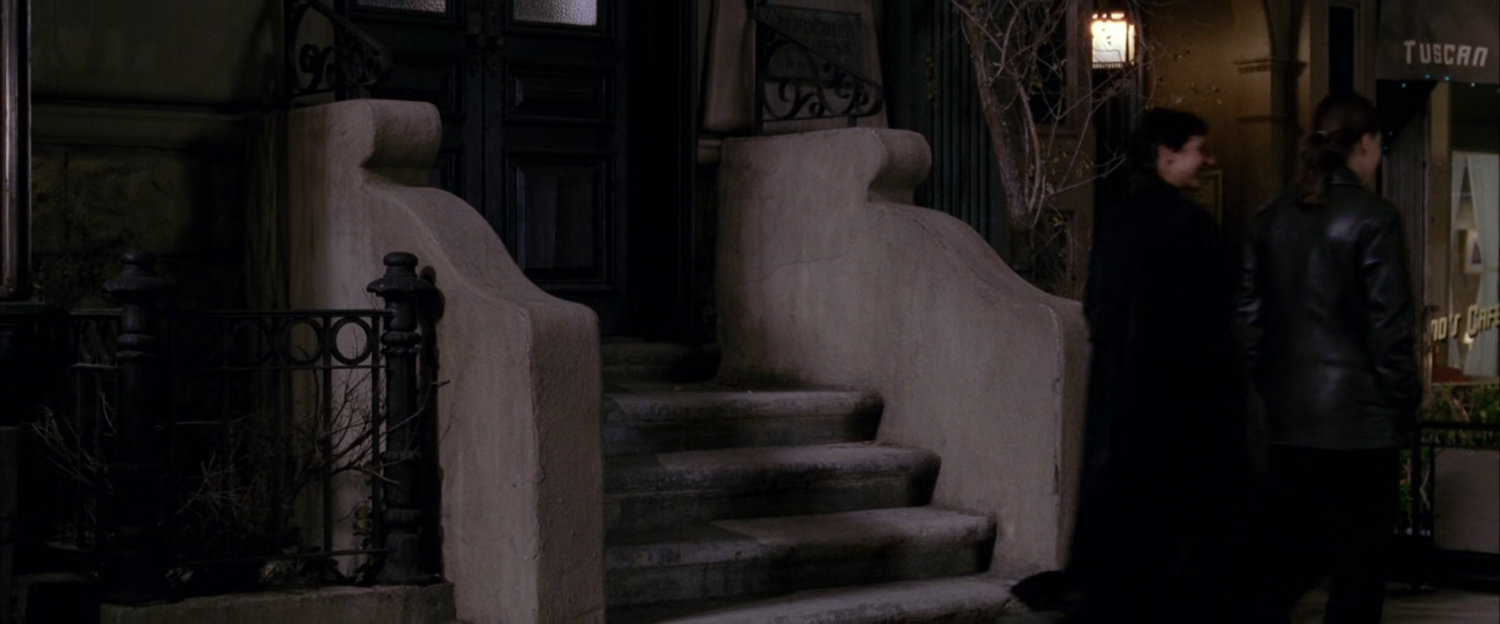 Empty brownstone stairway at night.