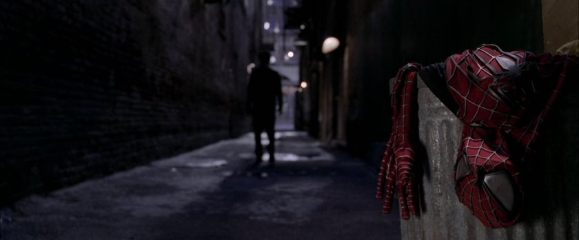 Spider-Man costume in trash can in dark alley.