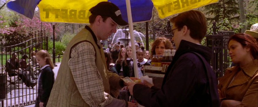 Peter Parker at hot dog vendor in park.