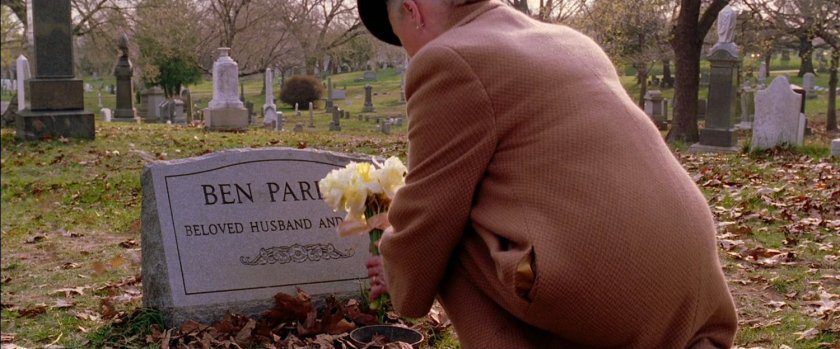 Aunt May putting flowers on Ben Parker grave.
