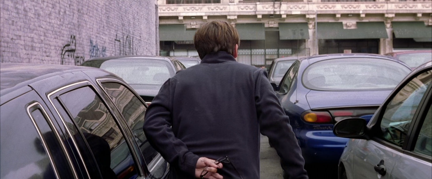 Peter Parker walking through parking lot.