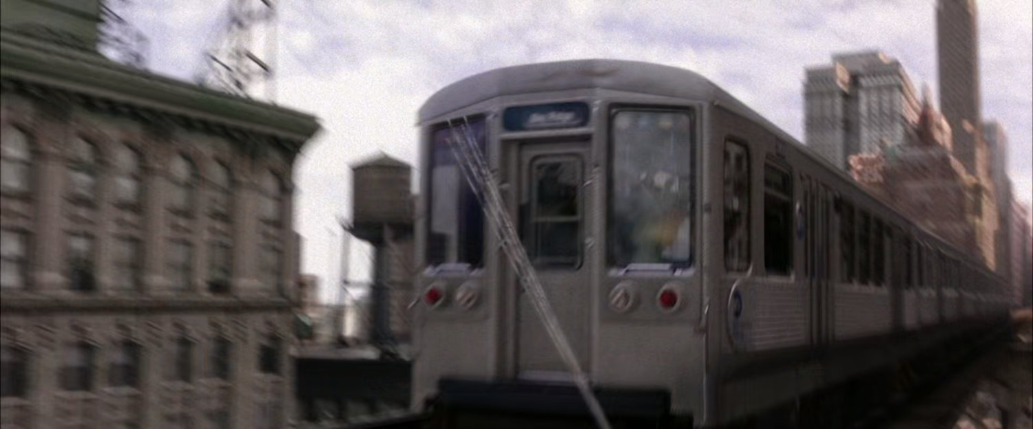 Web attaches to back of speeding train car.