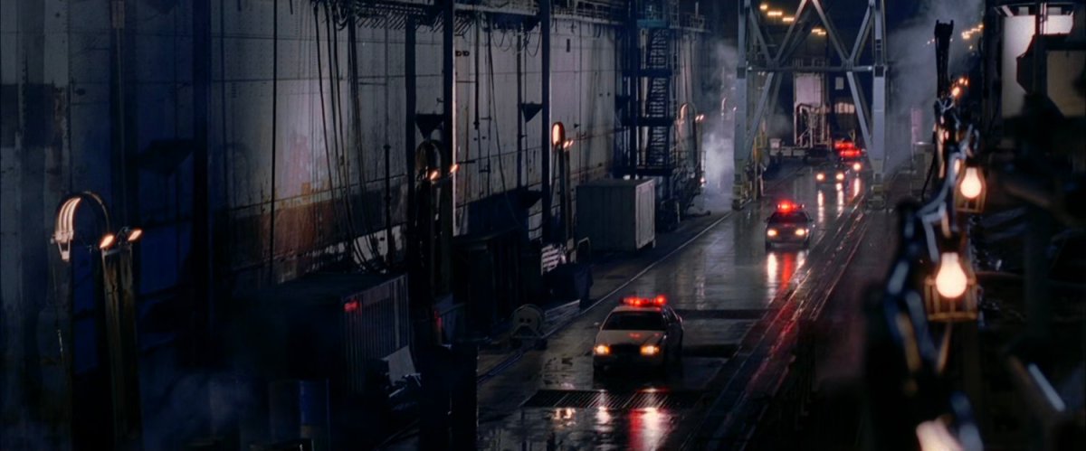 Police cars drive along cargo pier.