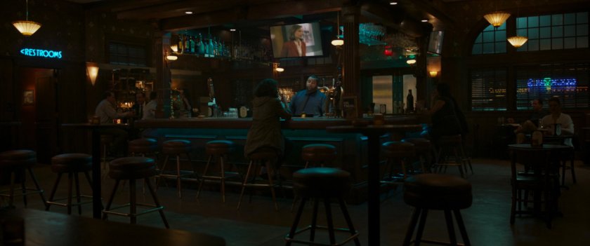 Jen Walters sits at the bar in the Legal Ease Bar & Grill nursing a drink, while Ally McBeal plays on TV.