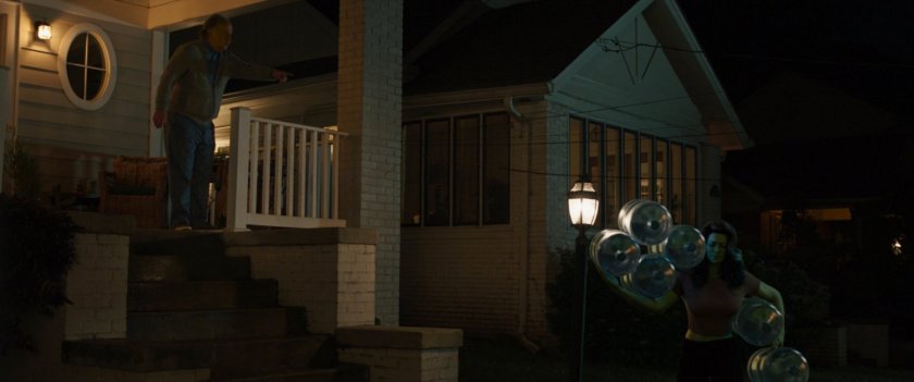 She-Hulk carries a number of heavy water bottles into Morris Walters' house.