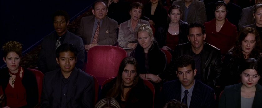 Audience in theater with empty chair.