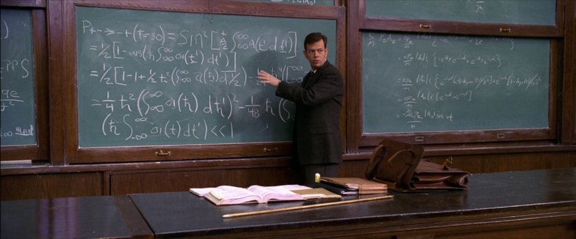 Professor Conners in front of blackboard in college classroom.