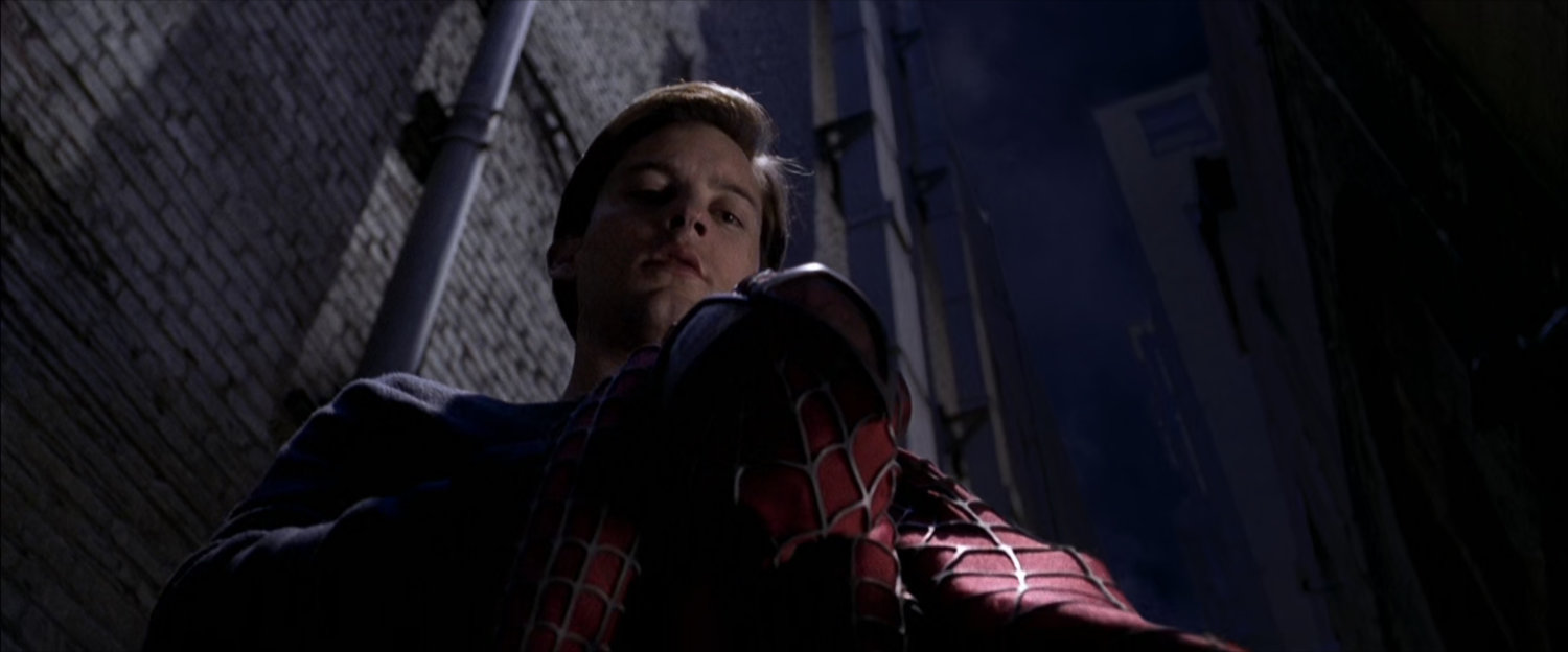 Peter Parker looks at his Spider-Man suit at night.