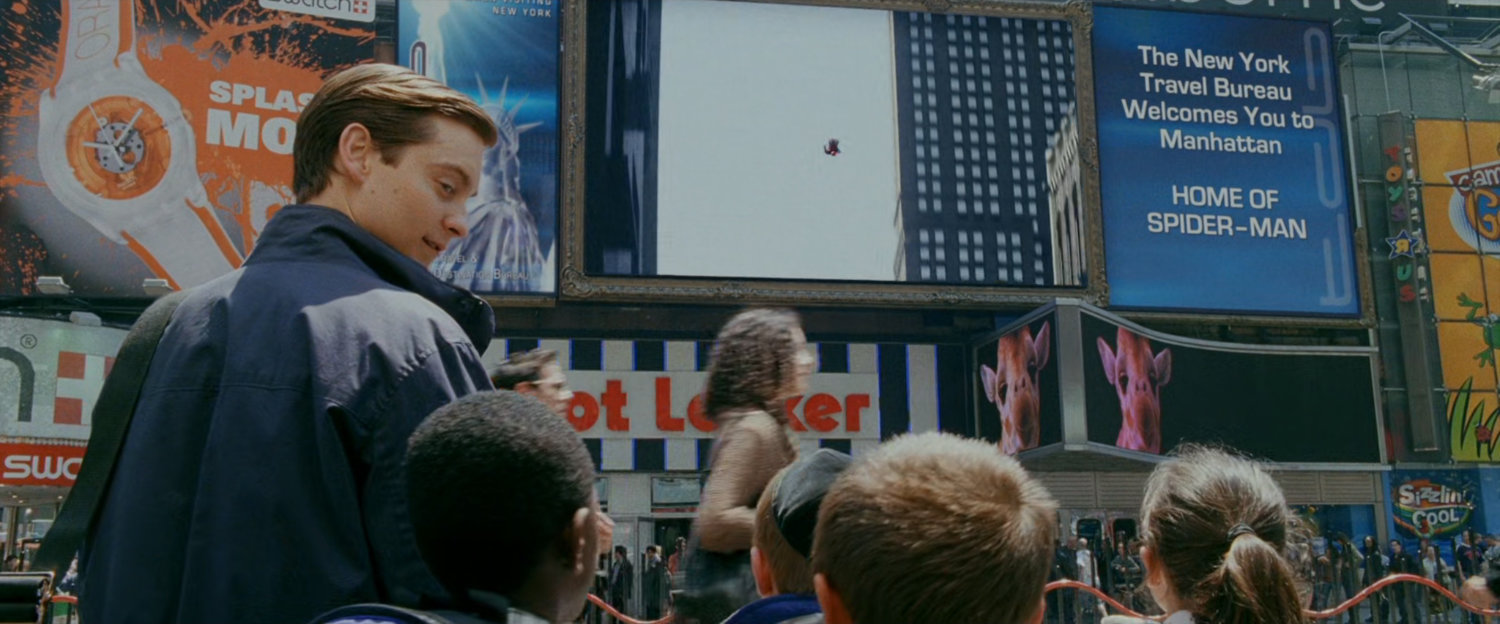 Peter Parker and children watch a video billboard in Times Square.