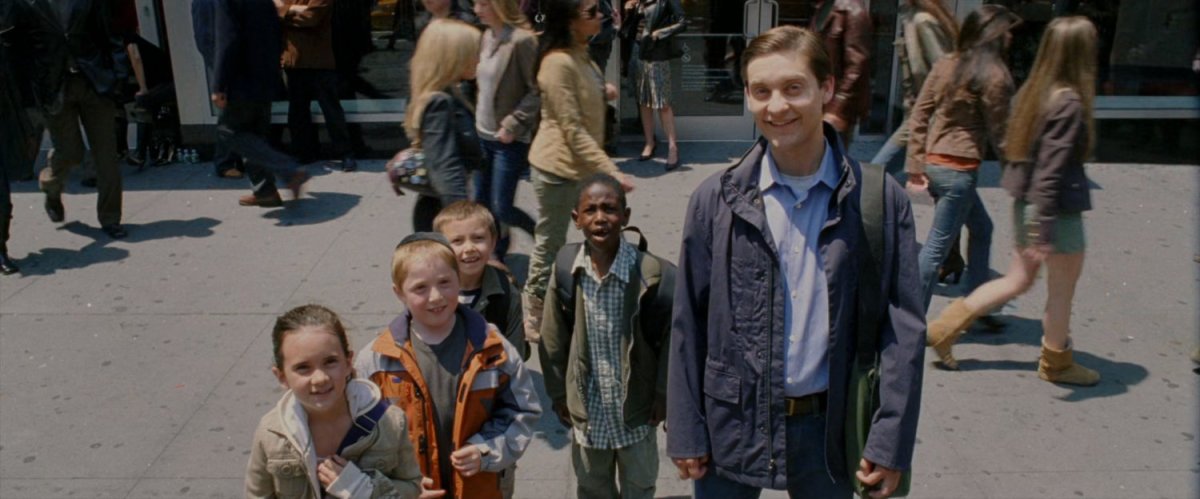 Peter Parker and children watch a video billboard in Times Square.