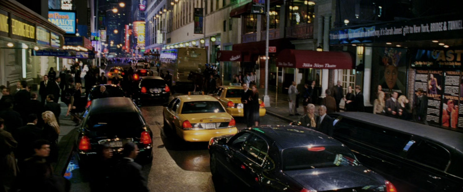 Busy New York street in theater district at night.