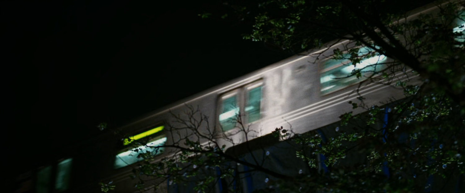 Elevated train speeding past at night.