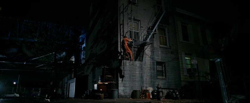 Flint Marko climbs fire escape.