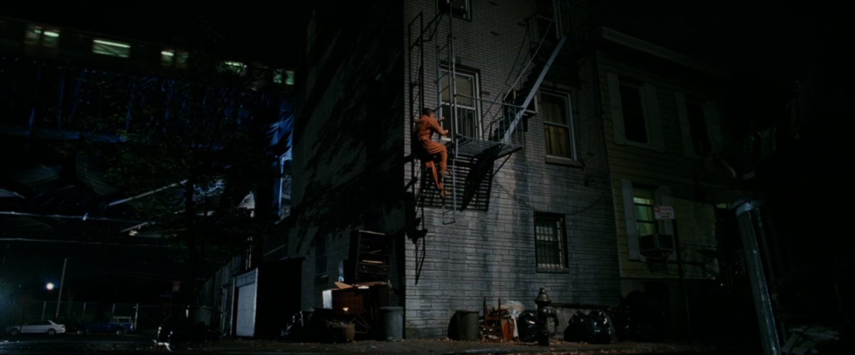 Flint Marko climbs fire escape.