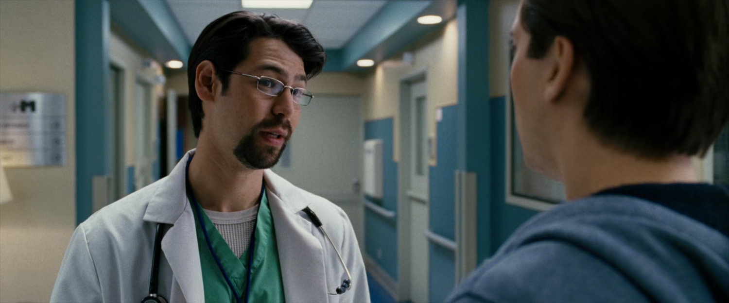 Peter Parker speaks to a doctor in hospital hallway.
