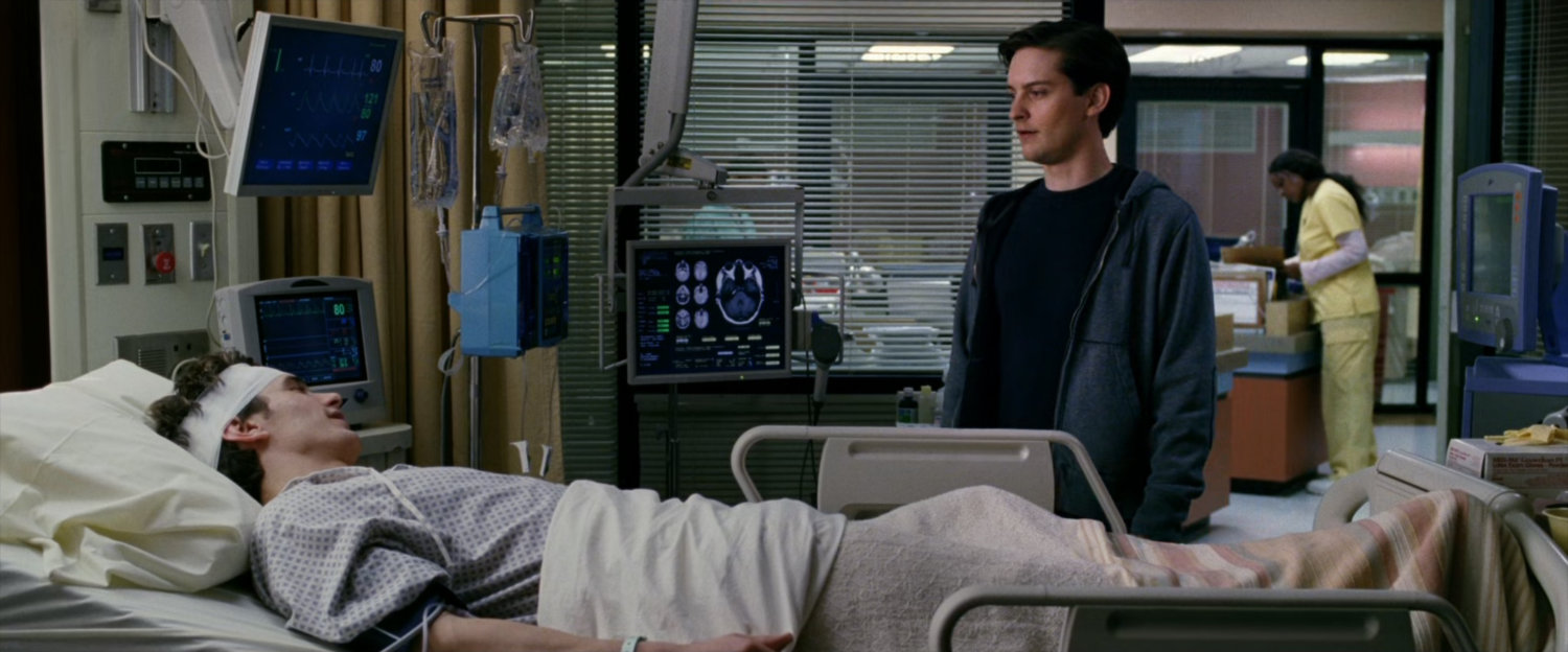 Peter Parker looks over Harry Osborn in hospital bed.