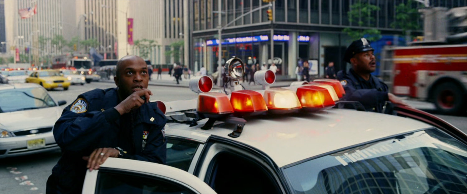 Police officers look up at a New York skyscraper.