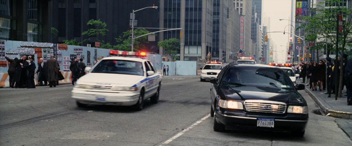 Police cars stop abruptly in the street.