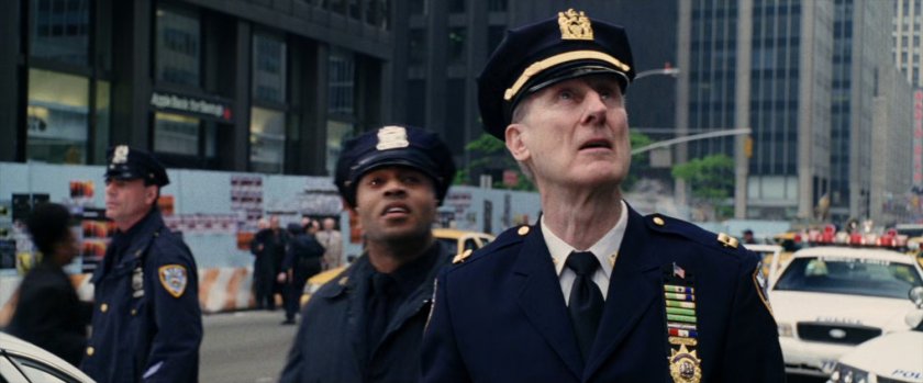 Captain Stacy and other officers look up at building.