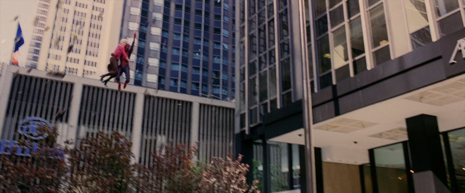 Spider-Man descends with Gwen Stacy over New York plaza.