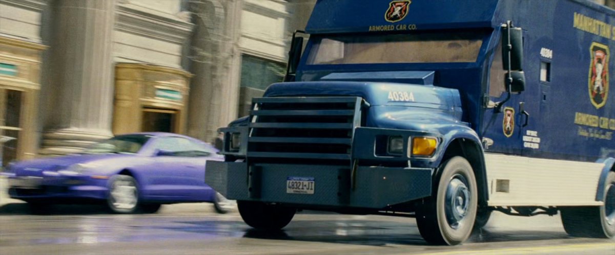 An armored truck speeding down a street.