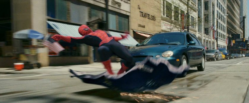 Spider-Man surfing on armored truck door.