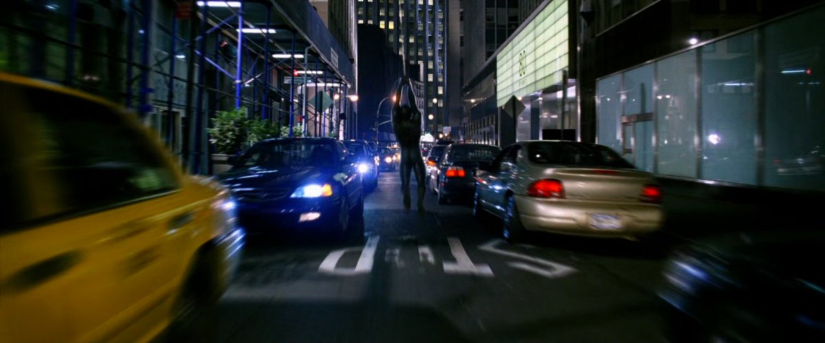 Spider-Man swinging down street.