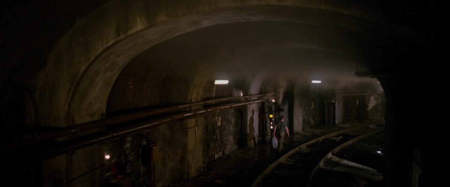 Sandman walks through subway tunnel.