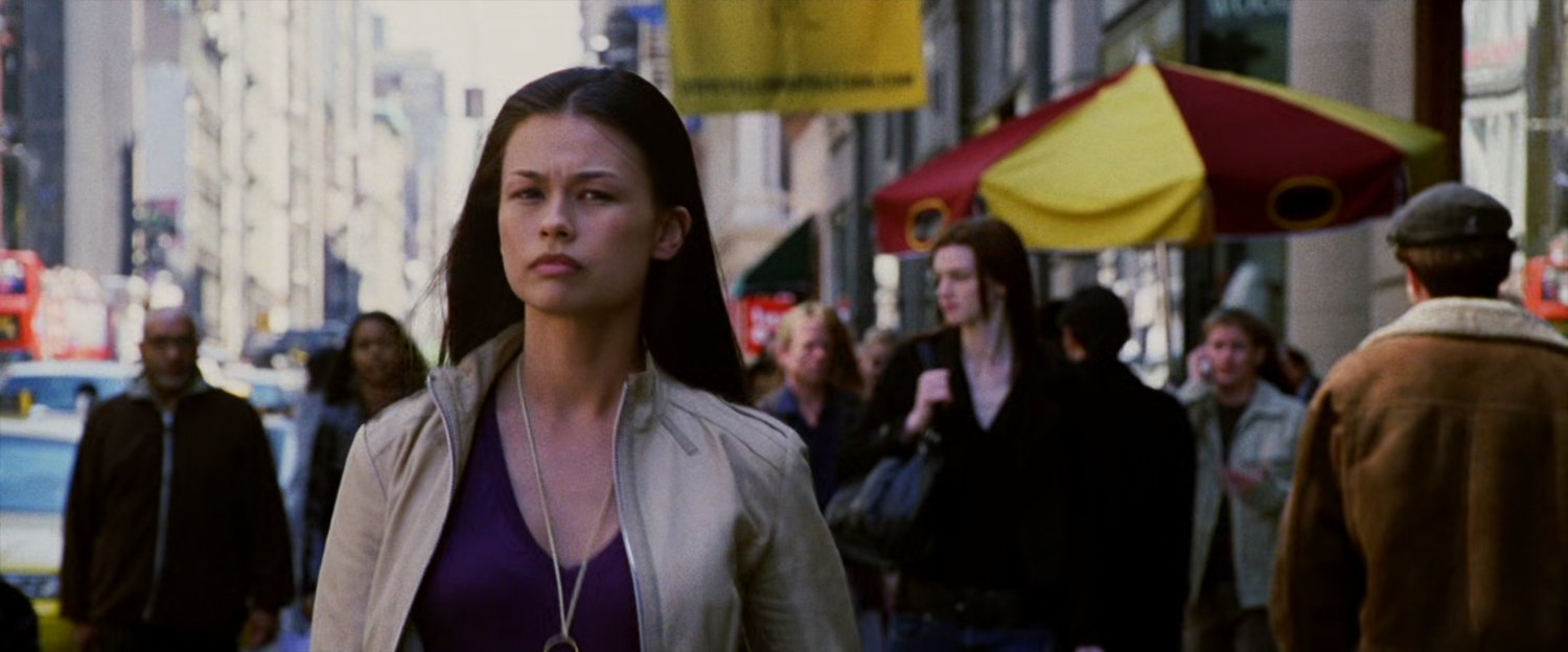 Woman walking down busy sidewalk.