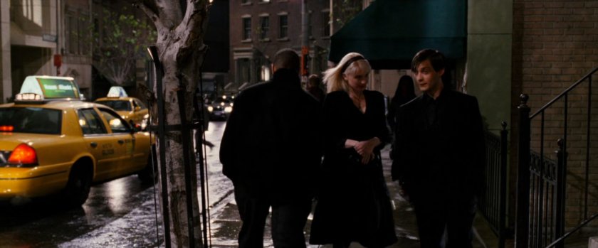 Peter Parker and Gwen Stacy on sidewalk at night.