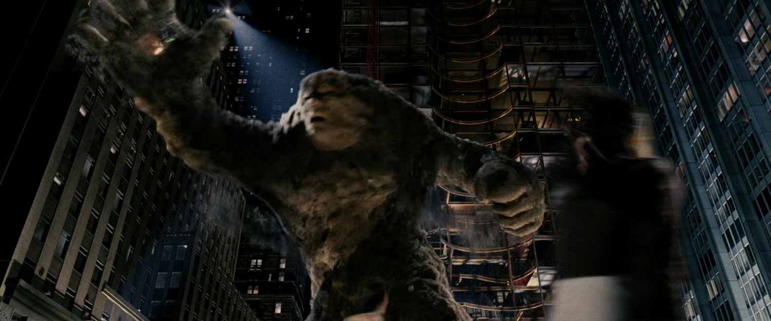 A giant sandman swats at a helicopter.