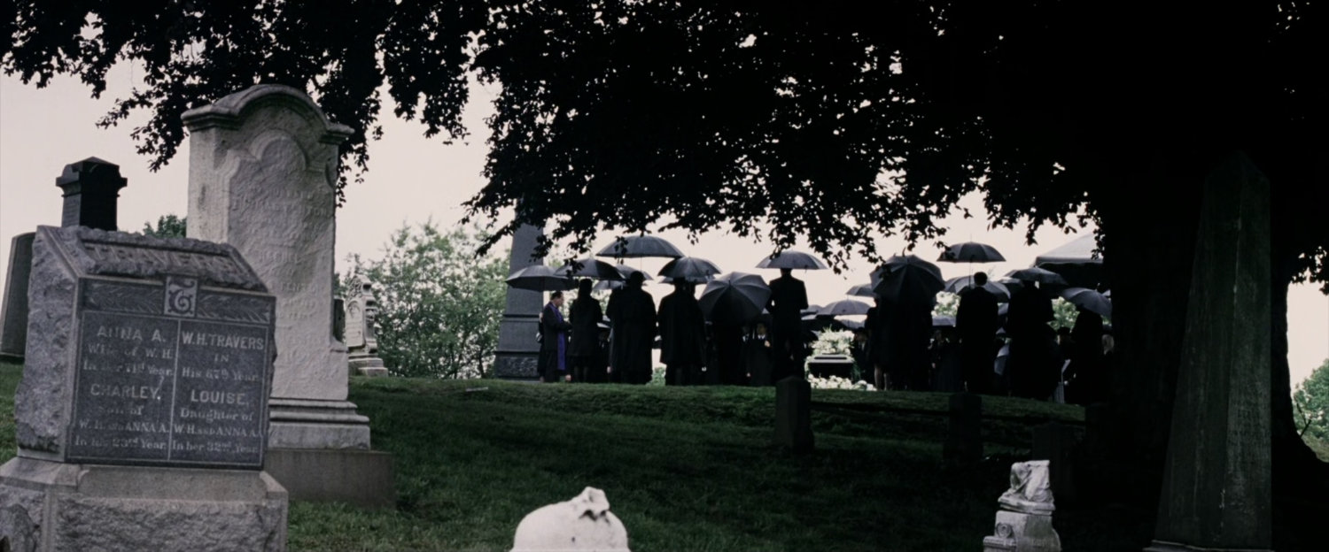 Mourners gather at a funeral at the cemetery.