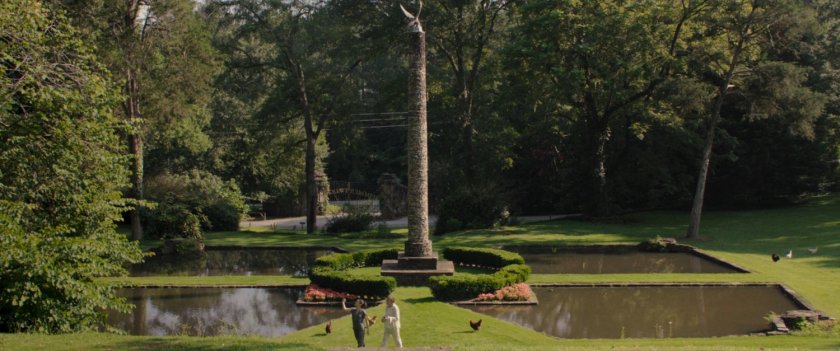 Jen Walters and Emil Blonsky walk past a column and ponds at the Summer Twilights retreat.