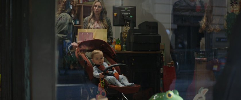 A baby in a stroller is visible inside the window of this store.