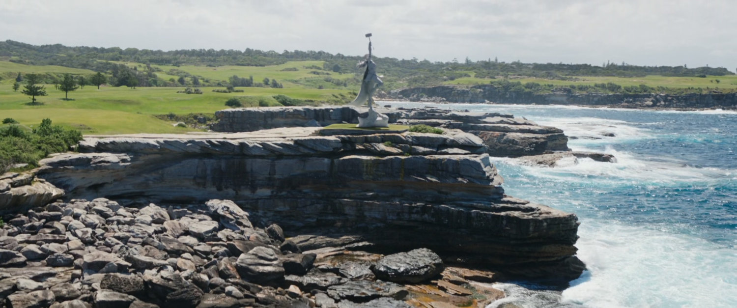 The coastline of New Asgard, with a statue of Mighty Thor.