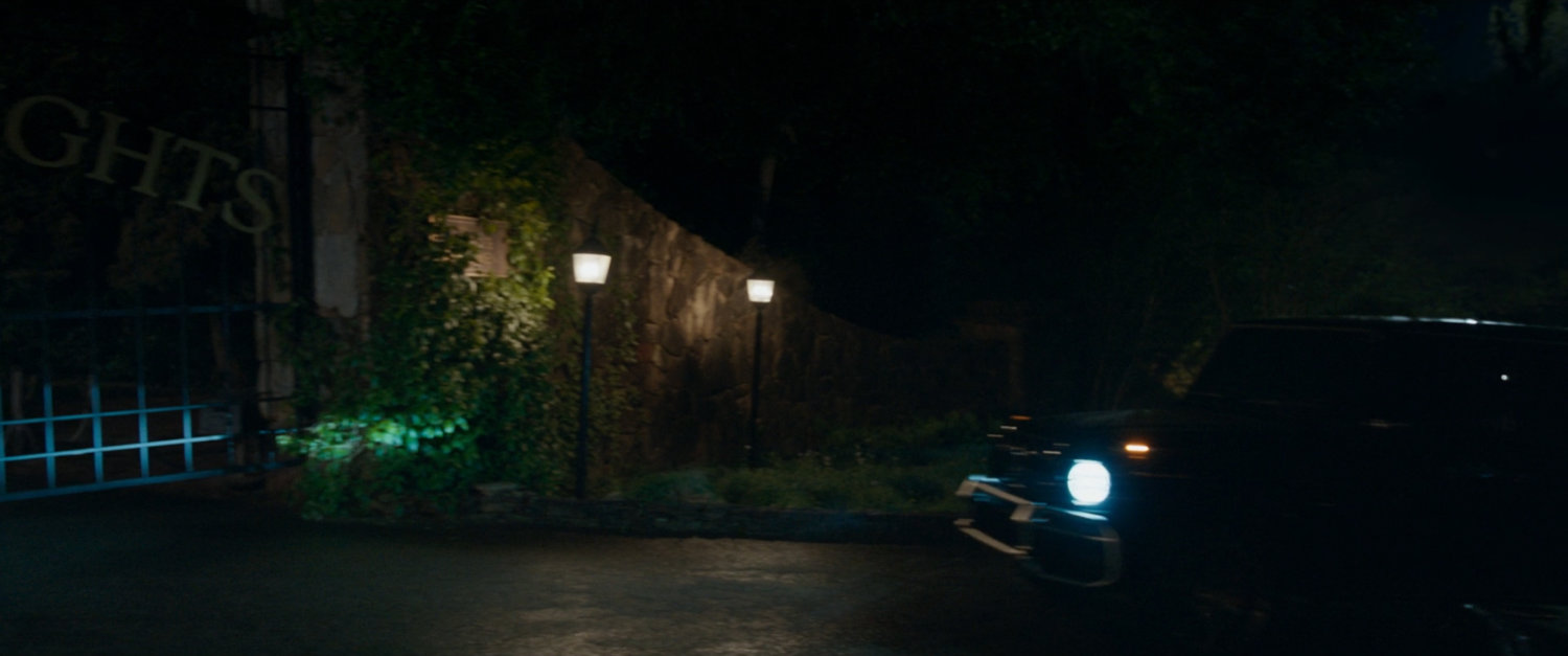 Exterior of Summer Twilights retreat at night as car pulls up to gate.