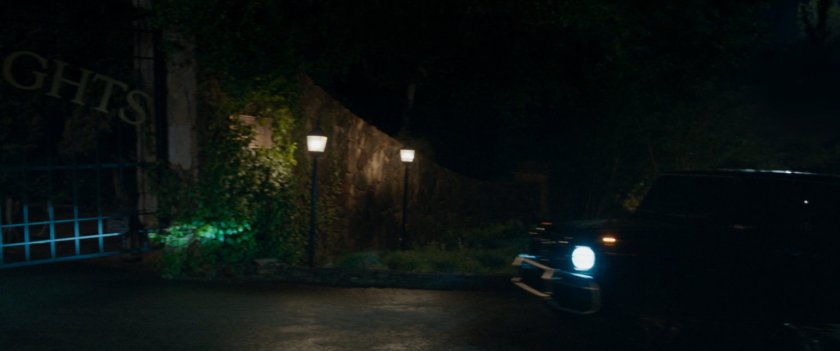 Exterior of Summer Twilights retreat at night as car pulls up to gate.