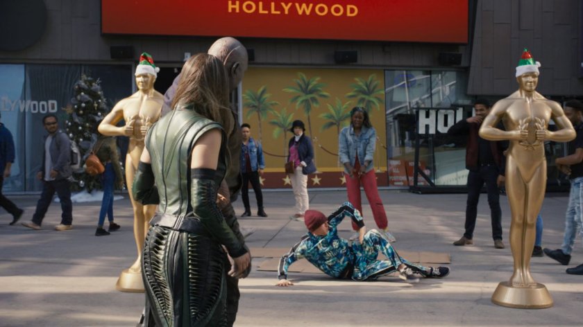 Drax and Mantis watch dancers in front of Madame Tussaud's Wax Museum.