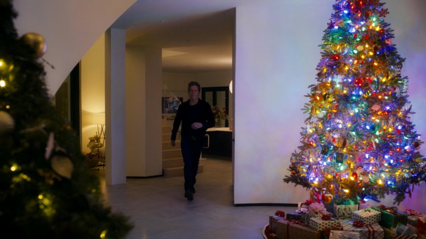 Kevin Bacon in his house with Christmas Trees.