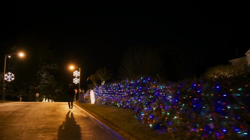 Kevin Bacon running down a street in a Beverly Hills neighborhood at night.